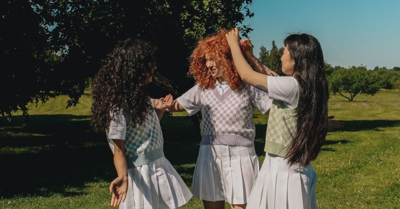 School Uniforms - Teenage Girls Standing on Green Grass Field