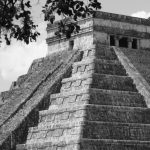 Mayan Prophecies - A black and white photo of people walking around the pyramid