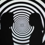 Hypnotism - Silhouette of 2 Person Standing in Front of White and Black Stripe Wall