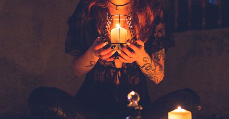 Cults - Spooky witch among candles during ritual