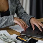 Savings Calculators - A Woman in Plaid Blazer Using Her Laptop