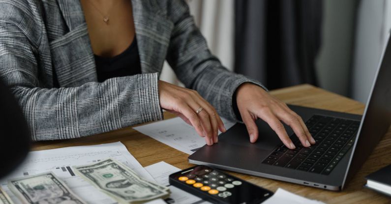 Savings Calculators - A Woman in Plaid Blazer Using Her Laptop